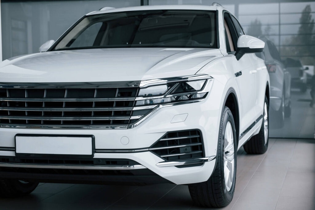 grey glass behind particle view of modern luxury white car parked indoors at daytime.jpg